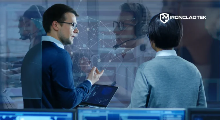 An image that represents the blog title: Is Your IT Proactive or Reactive? Here's How to Tell. Two men stand, speaking, wearing headsets, representing IT support.